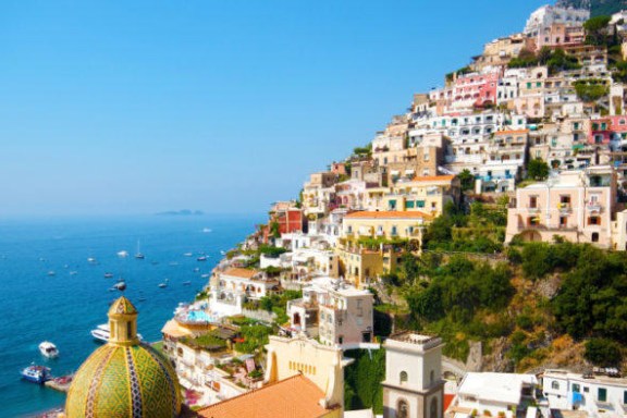 a large body of water with Amalfi Coast in the background